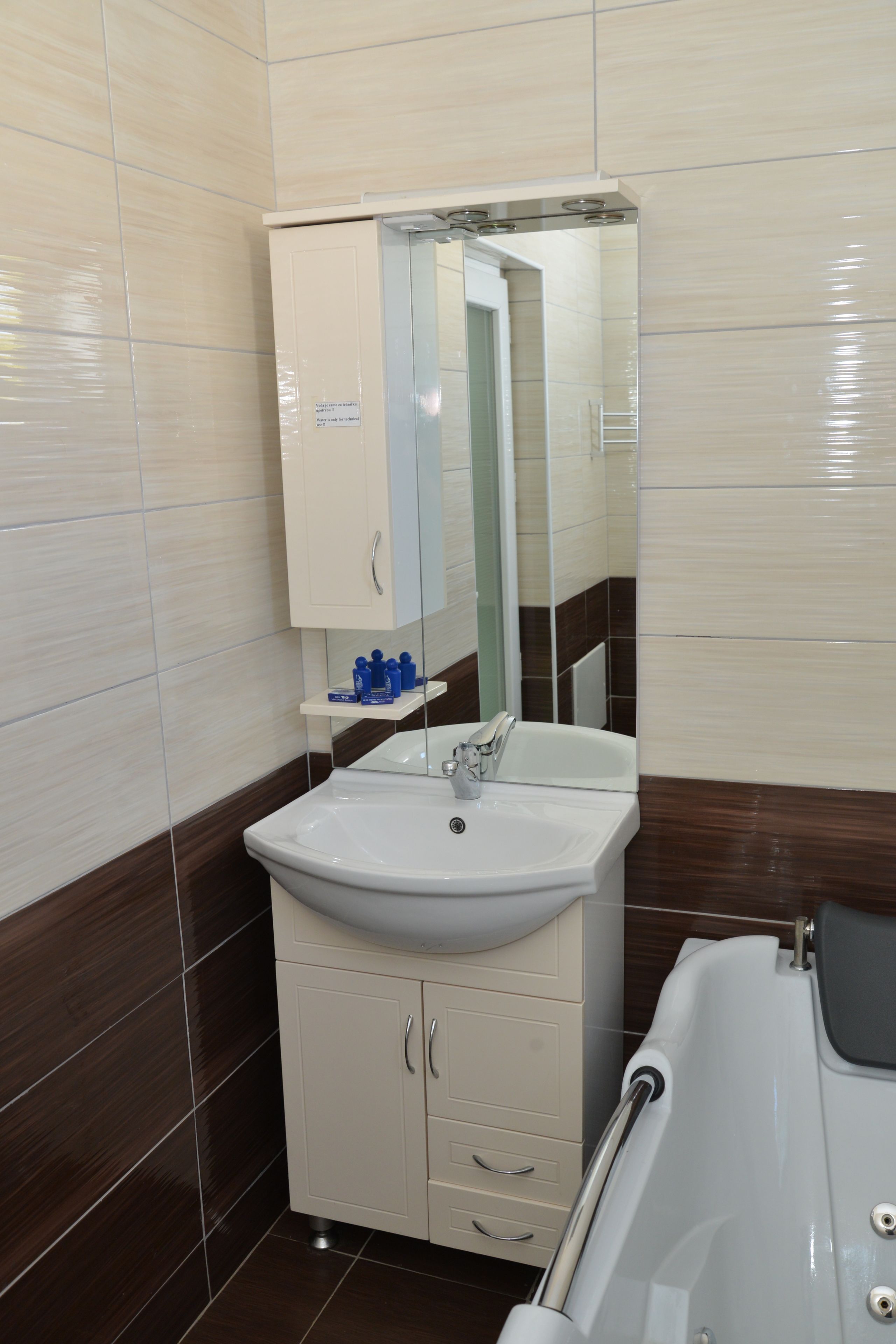 A bathroom with a white sink, a mirror above it, and a bathtub.