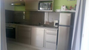 A kitchen with a microwave, coffee maker, and refrigerator. - SUBLIME F2 ANY COMFORT (Les Saintes)
