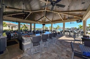 Relax in a tranquil outdoor space with tables, chairs, and a central bar area.