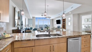 A modern kitchen with granite countertops, stainless steel appliances, and wooden cabinets. - Turquoise Place C2405 | Oversized, hot tub/grill on deck, huge slide for kids! (Orange Beach)