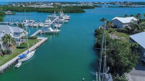 Un puerto deportivo con barcos amarrados, un muelle y un edificio de techo blanco.