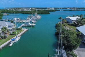 A marina with boats docked, a pier, and a building with a white roof.
