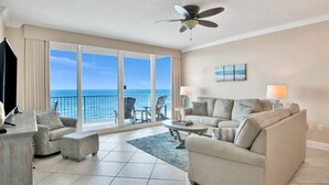 A spacious living room with a large sliding glass door leading to a balcony overlooking the ocean. - San Carlos 1009 | Beautiful, oversized, beach front, walk to Gulf Shores favorites! (Gulf Shores)