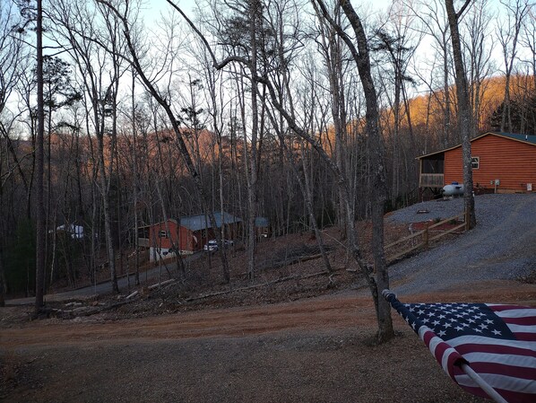 Eine Hütte, von Bäumen umgeben, mit einer amerikanischen Flagge im Vordergrund.