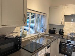 A kitchen with a microwave, toaster, sink, and oven.