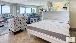 Ein modernes Hotelzimmer mit einem großen Bett, einer Couch, einem Sessel und einem Schreibtisch.