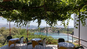 Una terraza con mesa y sillas, con vistas a un lago y montañas.