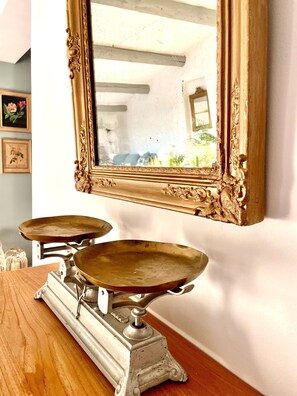 A vintage scale on a wooden table with a large ornate mirror above it. - Traditional Provence Village House with Rooftop Style & Boutique Chic (Villedieu)