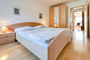 Une chambre à coucher avec un lit en bois, des tables de chevet et une armoire.
