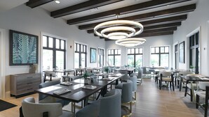 Un comedor amplio con varias mesas y sillas, ventanas grandes e iluminación colgante moderna.