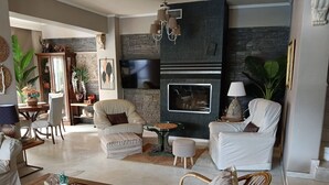 Ein modernes Wohnzimmer mit Kamin, bequemen Sitzmöglichkeiten und dekorativen Elementen.