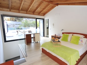 A bedroom with a bed, a desk, and a balcony. - Individual house, with 3 bedrooms, 3 bathrooms, living room, kitchen, garden (La Orotava)
