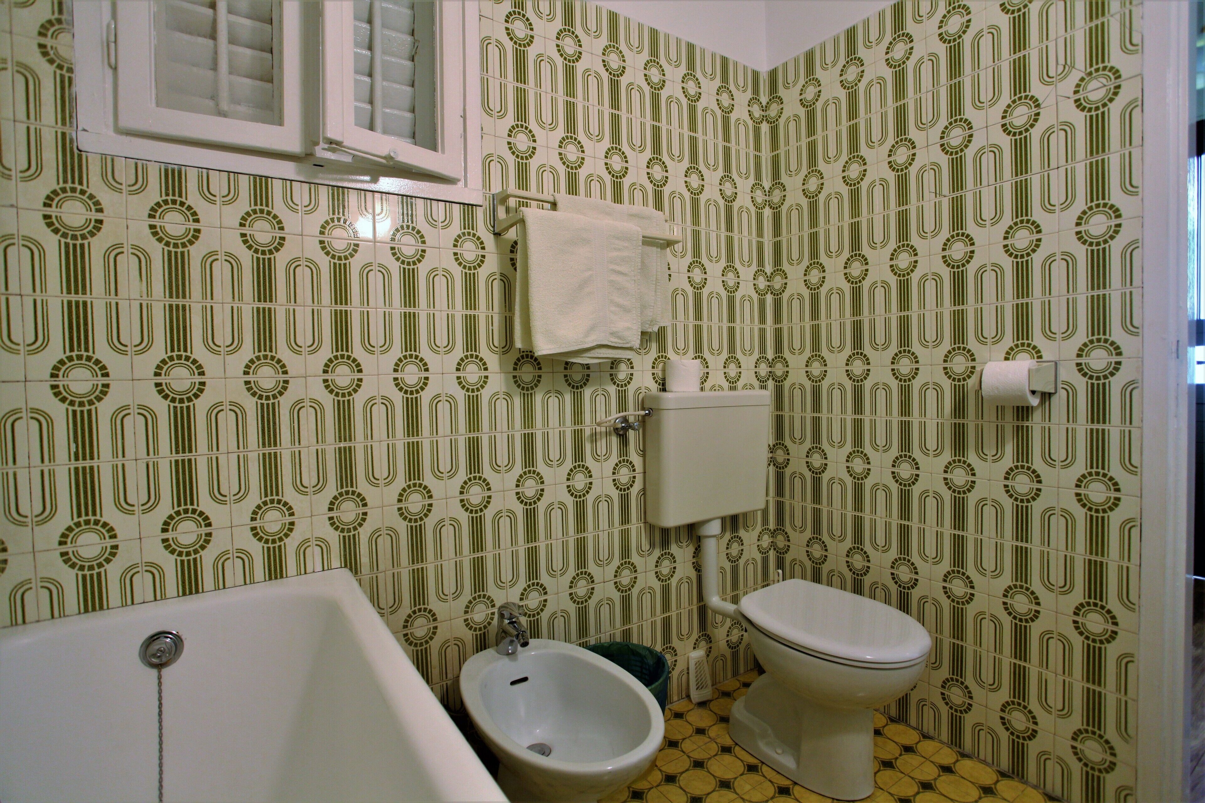 Ein Badezimmer mit Bidet, Toilette und Badewanne.