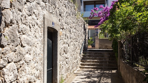 Un estrecho sendero de piedra que conduce a un edificio con una puerta marcada con el número 8.