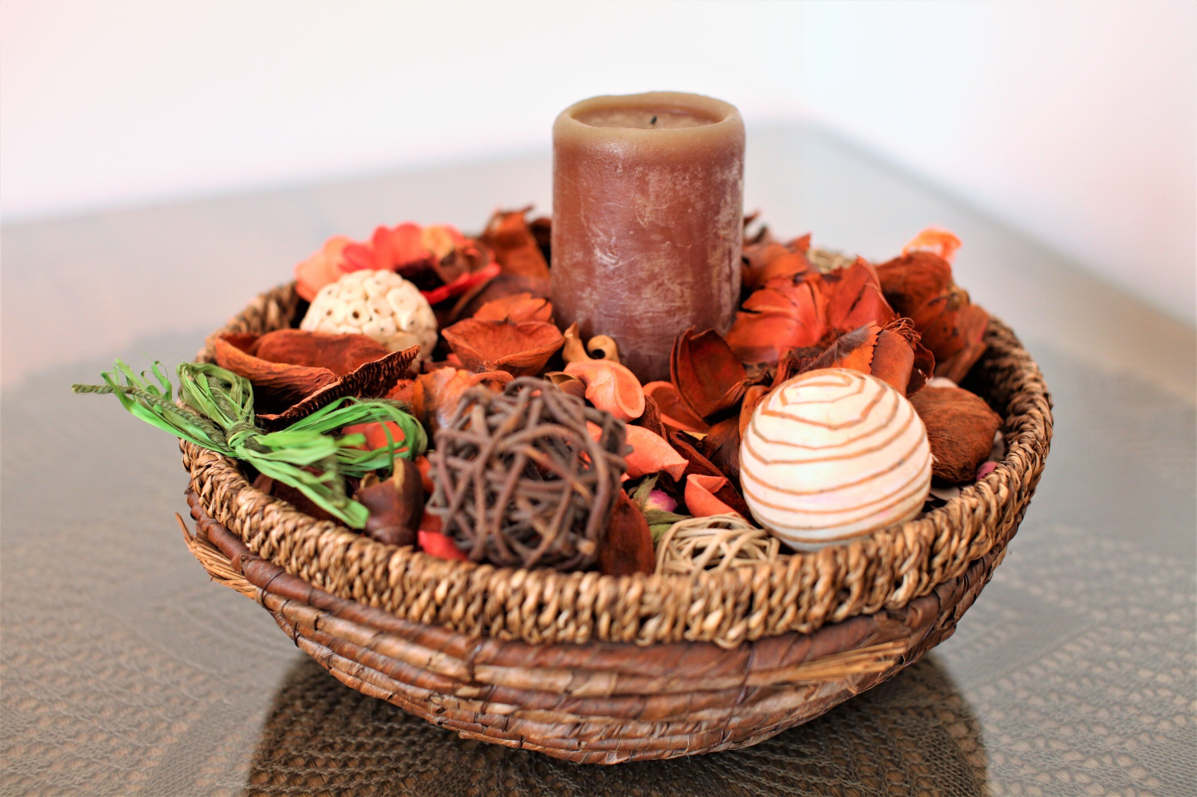 Ein Korankorb mit Kerze, getrockneten Blumen und Dekoration.