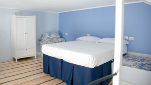 A bedroom with a single bed, a white wardrobe, and a patterned rug. - Casa Niccolò 5 (max 4 pp) (Napoli)