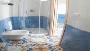 A bathroom with a shower, a sink, and patterned floor tiles. - Casa Niccolò 5 (max 4 pp) (Napoli)