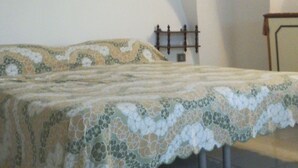 A bedroom with a bed, a ceiling fan, and a wall-mounted shelf. - Simona holiday home. (TAVIANO)