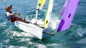 A person sailing a small sailboat with a purple sail. - Independent beachfront accommodation. (valledoria)