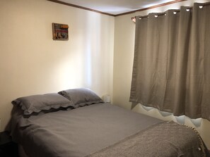 Cozy retreat with a single bed, artwork, and window.