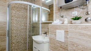 A modern bathroom with a glass-enclosed shower, a white sink, and a mirror above it. - Guest House Nikolina - Double Room(6) (Dubrovnik)