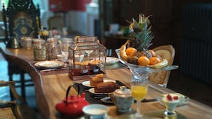 A breakfast table with a fruit bowl, pastries, and a teapot. - Villa Alecya (Sainte-Catherine-de-Fierbois)