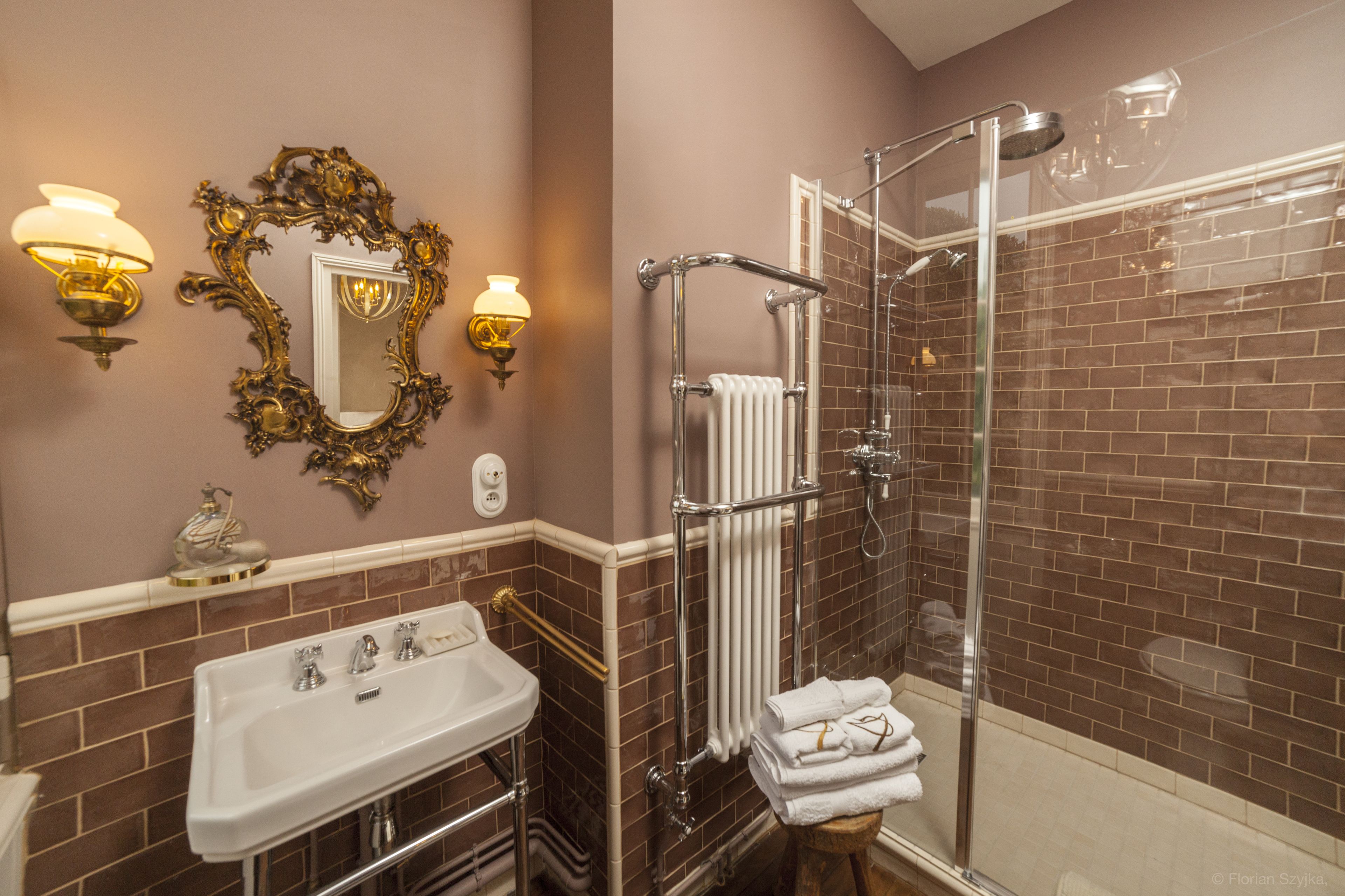 A bathroom with a sink, mirror, and shower.