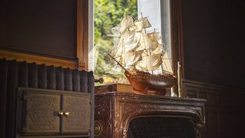 A model ship on a wooden cabinet near a window.