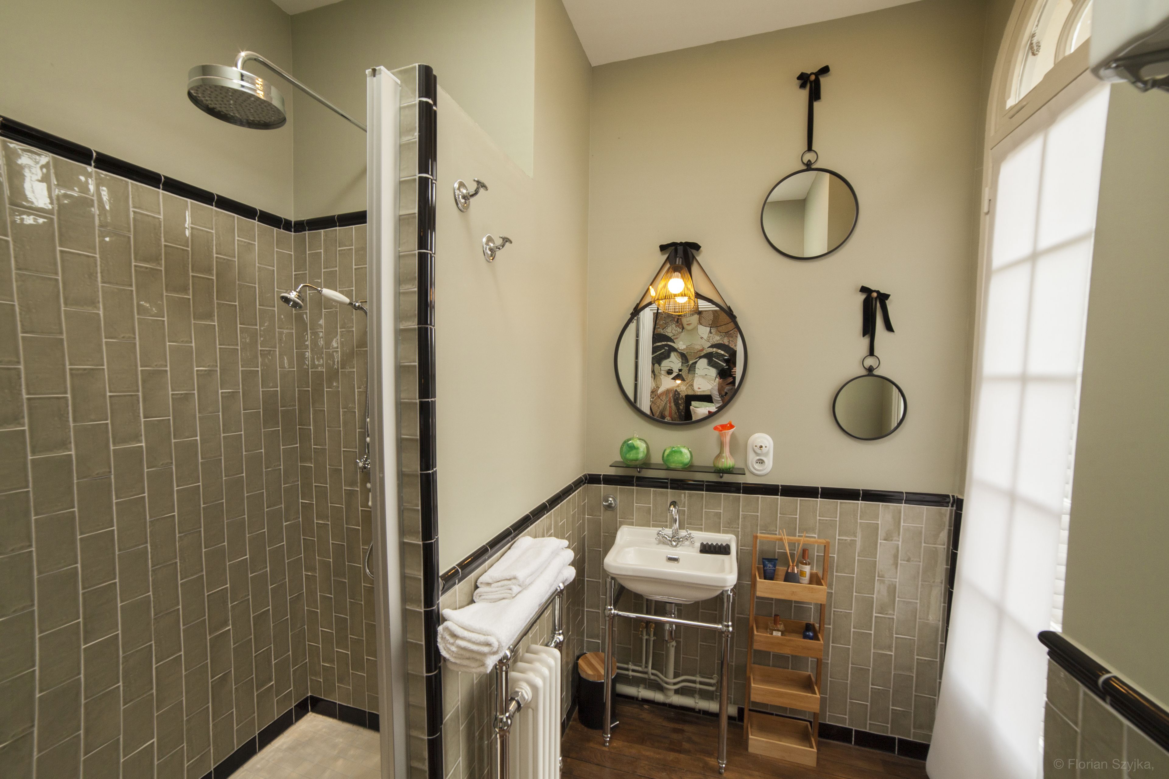 A bathroom with a shower, sink, and two mirrors.