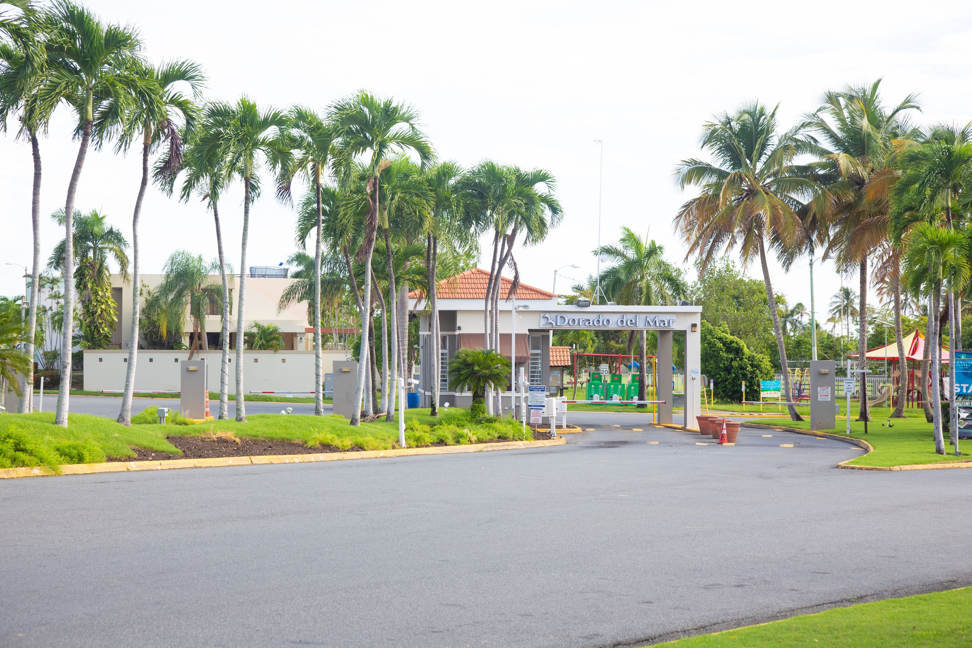 A gated entrance with a sign reading 'Porado del Mar' and a playground in the background.