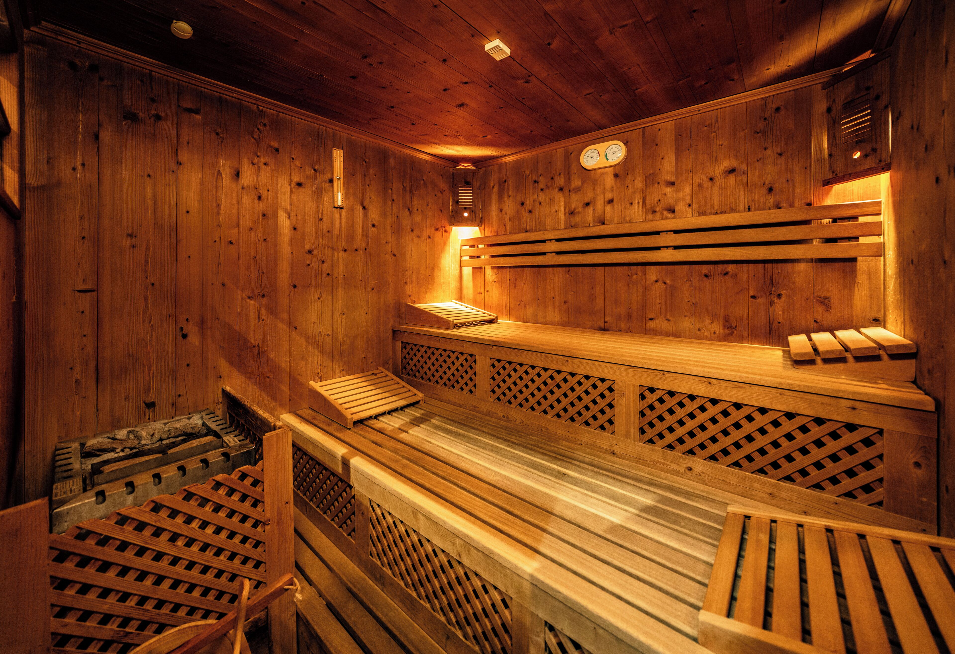 Una sauna de madera con bancos y un banco con respaldo.