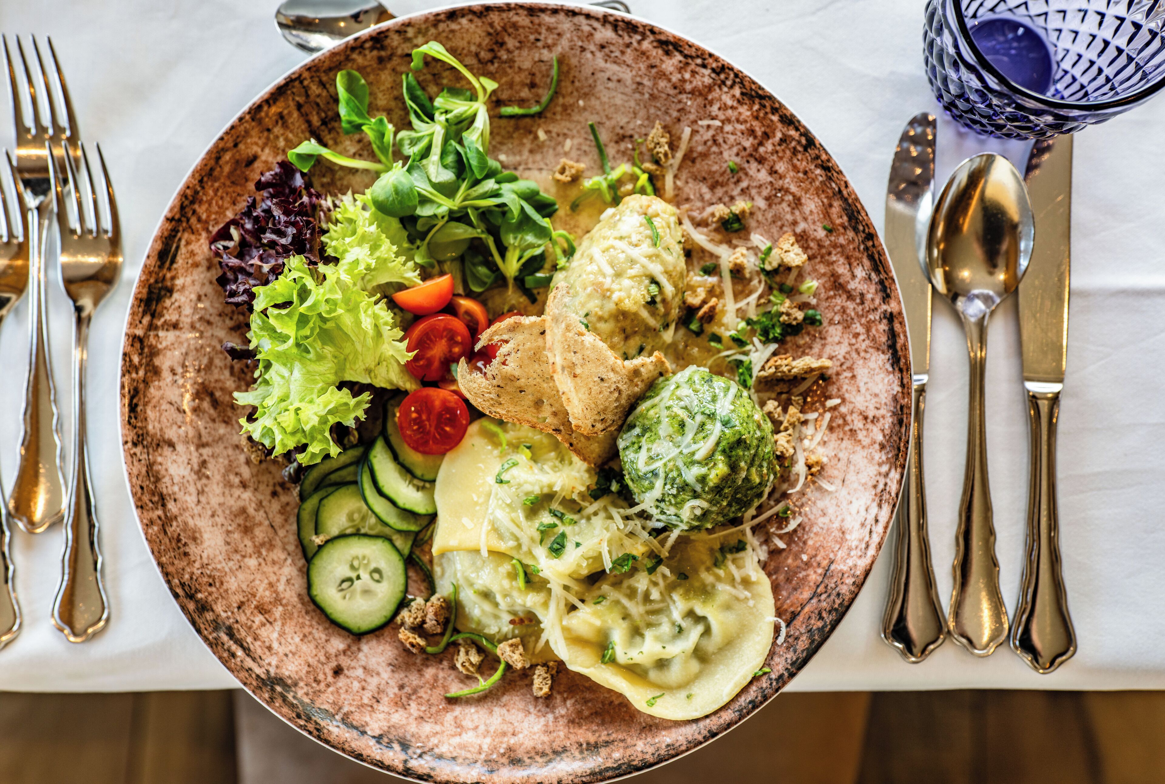 A plate of food with various items including pasta, vegetables, and bread.