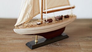 Ein Modellsegelboot auf einem Holzständer.