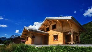 Une cabane en bois avec un toit en pente, une véranda et un garage.
