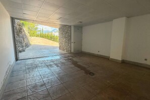 A hallway with a stone wall on one side and a tiled floor leading to a door. - VillaTierra. Luxury villa. Best Views in Nerja (Nerja)