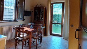 Un coin repas avec une table et des chaises en bois, un buffet et une fenêtre avec des rideaux.