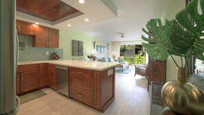 Una cocina con armarios de madera, un refrigerador de acero inoxidable y una isla grande.