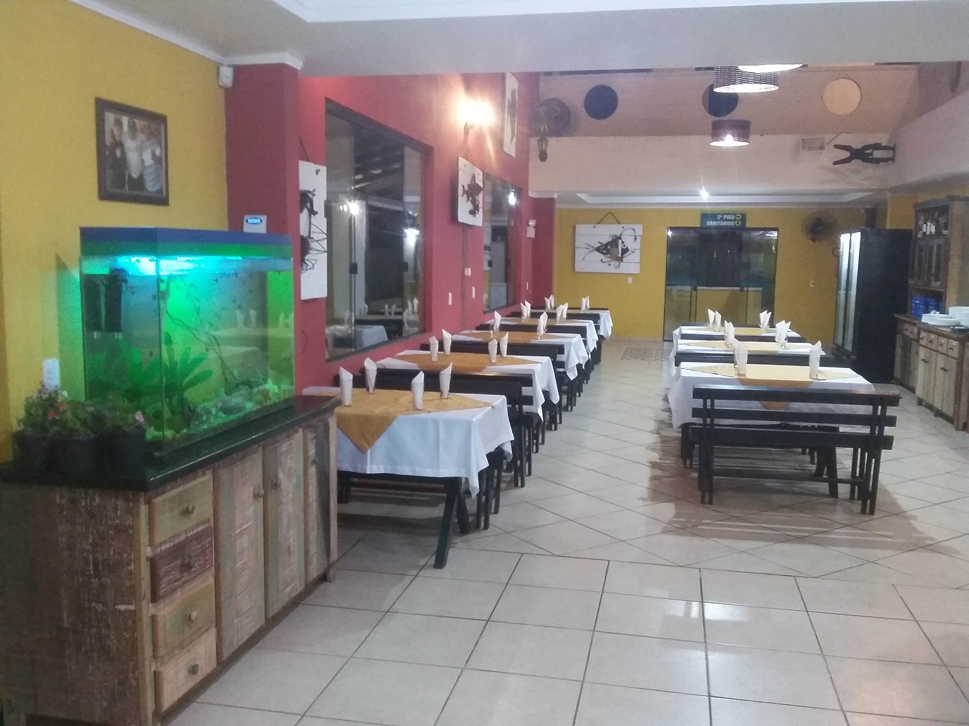A restaurant with multiple tables, a fish tank, and a sign indicating a sanitary area.