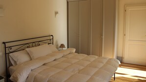 Una camera da letto con un letto, un armadio e un comodino.