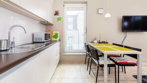 Una cocina moderna con microondas, lavaplatos y comedor con sillas y mesa.