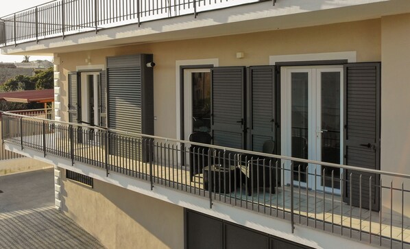 A residential building with a balcony, a gated entrance, and a logo indicating it is a property of Antonio & Maria's.