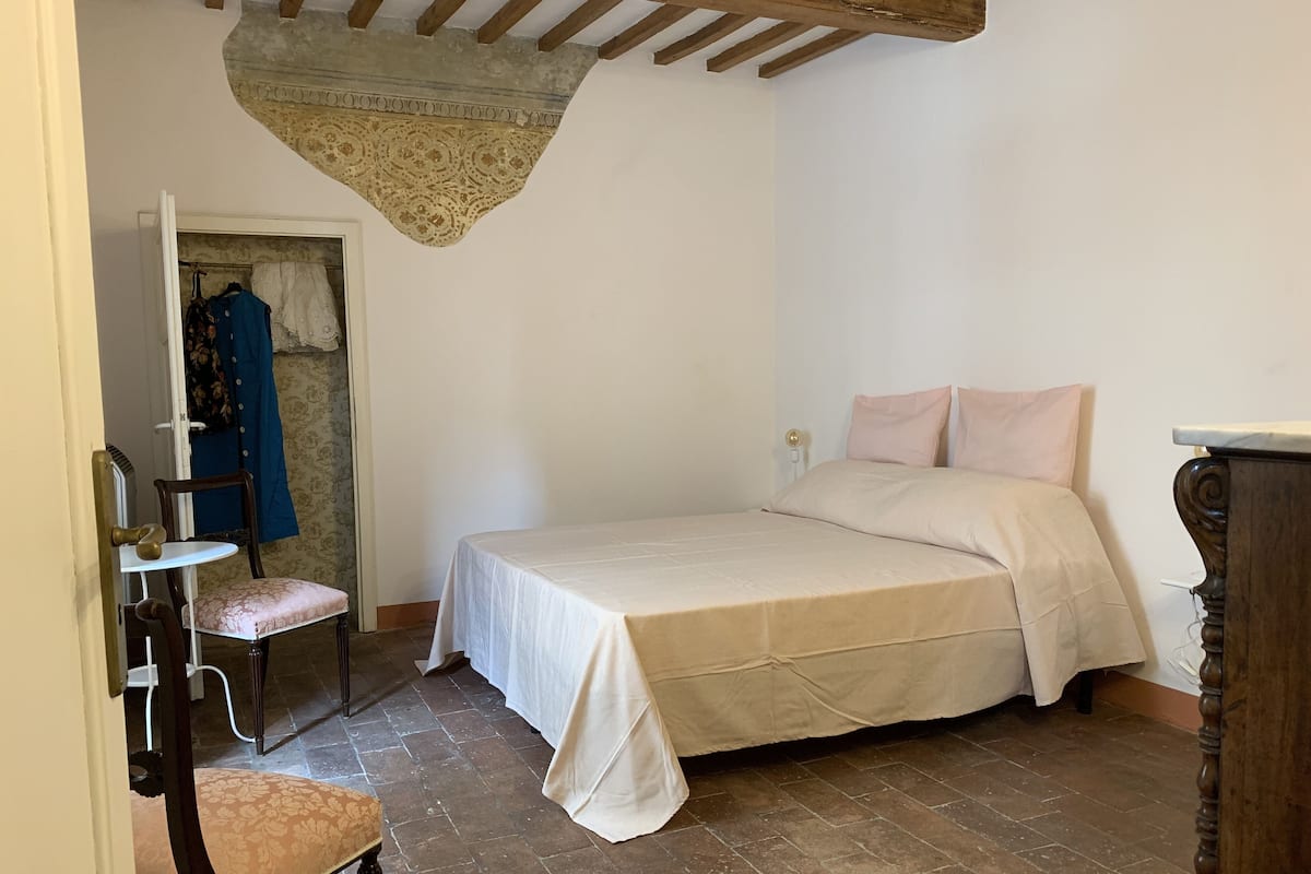 Une chambre à coucher avec un lit, une chaise et une armoire.