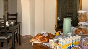 Una mesa de desayuno con pasteles, bebidas y un espejo.