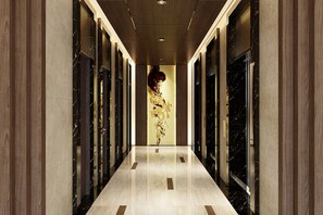 Stunning corridor with ornate mirror, patterned wallpaper, and elegant columns.