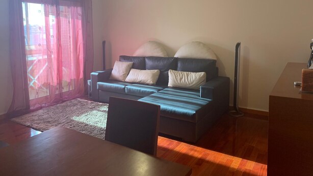 A living room with a sofa, a dining table, and a ceiling fan. - Apartment Braga Parque (Braga)