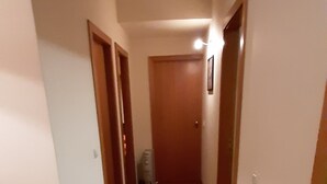 A hallway with wooden flooring and doors on both sides. - Apartment Braga Parque (Braga)