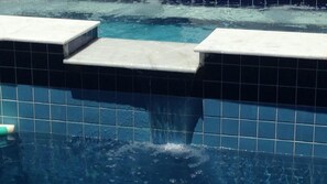 A pool with tiled edges and a visible water feature. - GATED COMMUNITY, 24-HOUR SECURITY, SWIMMING POOL WITH HYDROMASSAGE.  (Peruíbe - SP)
