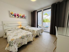 Une chambre d’hôtel avec deux lits, un tableau au mur et une vue sur l’extérieur.
