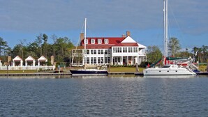 A waterfront property with a large house, a dock, and several boats. - Ballast Point Bungalow - Waterfront Harmony (Oriental)