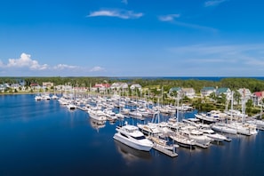 Boats docked in a serene marina surrounded by homes and lush greenery.